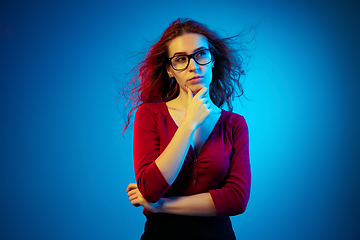 Image showing Caucasian woman\'s portrait isolated on blue studio background in neon light