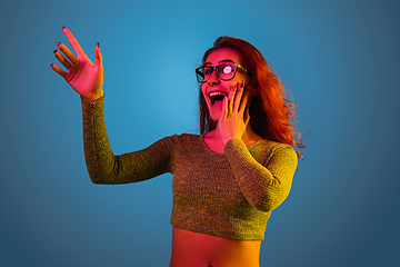 Image showing Caucasian woman\'s portrait isolated on blue studio background in neon light