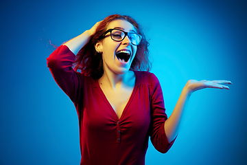 Image showing Caucasian woman\'s portrait isolated on blue studio background in neon light