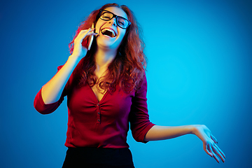 Image showing Caucasian woman\'s portrait isolated on blue studio background in neon light