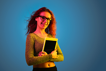 Image showing Caucasian woman\'s portrait isolated on blue studio background in neon light