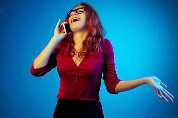 Image showing Caucasian woman\'s portrait isolated on blue studio background in neon light