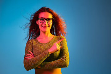 Image showing Caucasian woman\'s portrait isolated on blue studio background in neon light