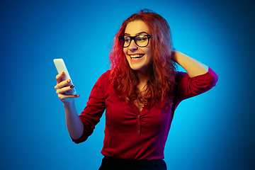 Image showing Caucasian woman\'s portrait isolated on blue studio background in neon light