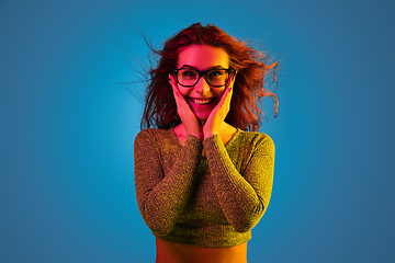 Image showing Caucasian woman\'s portrait isolated on blue studio background in neon light