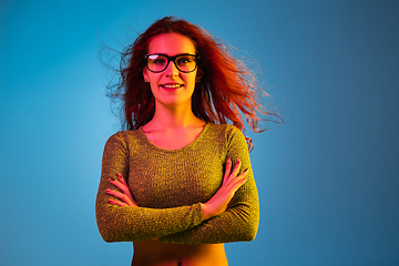 Image showing Caucasian woman\'s portrait isolated on blue studio background in neon light