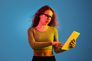 Image showing Caucasian woman\'s portrait isolated on blue studio background in neon light