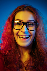 Image showing Caucasian woman\'s portrait isolated on blue studio background in neon light