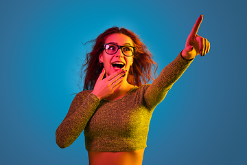 Image showing Caucasian woman\'s portrait isolated on blue studio background in neon light