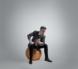 Image showing Caucasian man in office clothes training isolated on grey studio background