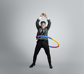 Image showing Caucasian man in office clothes training isolated on grey studio background