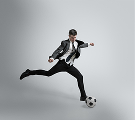 Image showing Caucasian man in office clothes training isolated on grey studio background