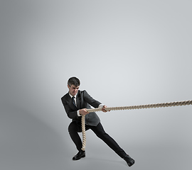 Image showing Caucasian man in office clothes training isolated on grey studio background