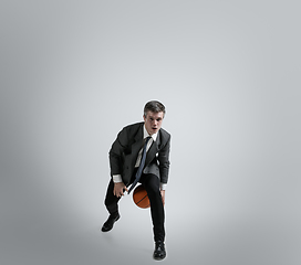 Image showing Caucasian man in office clothes training isolated on grey studio background