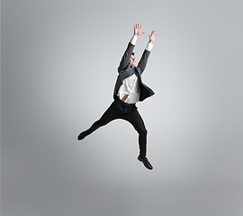 Image showing Caucasian man in office clothes training isolated on grey studio background