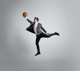 Image showing Caucasian man in office clothes training isolated on grey studio background