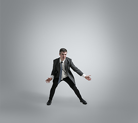 Image showing Caucasian man in office clothes training isolated on grey studio background