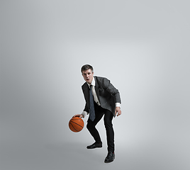 Image showing Caucasian man in office clothes training isolated on grey studio background