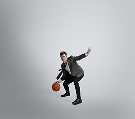 Image showing Caucasian man in office clothes training isolated on grey studio background