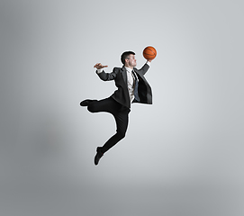 Image showing Caucasian man in office clothes training isolated on grey studio background