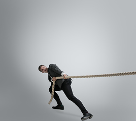 Image showing Caucasian man in office clothes training isolated on grey studio background