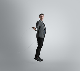 Image showing Caucasian man in office clothes training isolated on grey studio background