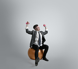 Image showing Caucasian man in office clothes training isolated on grey studio background