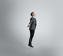 Image showing Caucasian man in office clothes training isolated on grey studio background