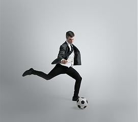 Image showing Caucasian man in office clothes training isolated on grey studio background