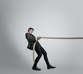 Image showing Caucasian man in office clothes training isolated on grey studio background