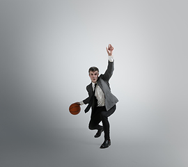 Image showing Caucasian man in office clothes training isolated on grey studio background