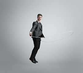 Image showing Caucasian man in office clothes training isolated on grey studio background