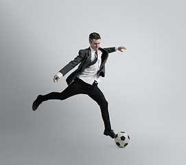 Image showing Caucasian man in office clothes training isolated on grey studio background