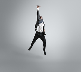 Image showing Caucasian man in office clothes training isolated on grey studio background