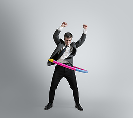 Image showing Caucasian man in office clothes training isolated on grey studio background