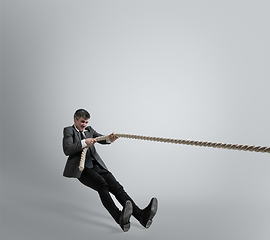 Image showing Caucasian man in office clothes training isolated on grey studio background