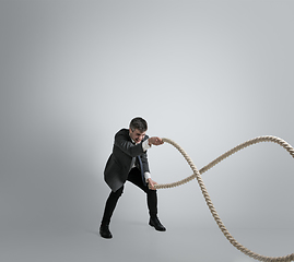 Image showing Caucasian man in office clothes training isolated on grey studio background