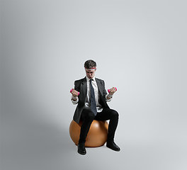 Image showing Caucasian man in office clothes training isolated on grey studio background