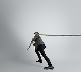 Image showing Caucasian man in office clothes training isolated on grey studio background