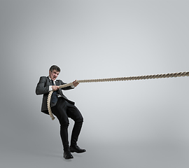 Image showing Caucasian man in office clothes training isolated on grey studio background