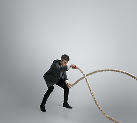 Image showing Caucasian man in office clothes training isolated on grey studio background