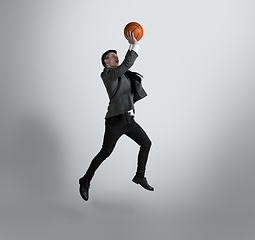 Image showing Caucasian man in office clothes training isolated on grey studio background