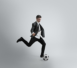 Image showing Caucasian man in office clothes training isolated on grey studio background