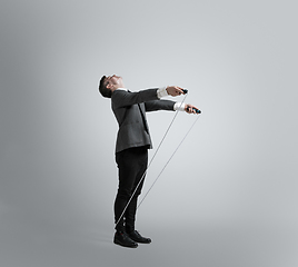 Image showing Caucasian man in office clothes training isolated on grey studio background