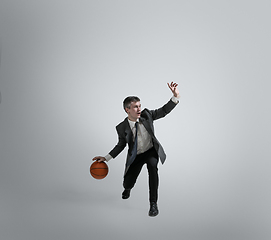 Image showing Caucasian man in office clothes training isolated on grey studio background