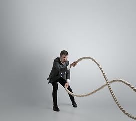 Image showing Caucasian man in office clothes training isolated on grey studio background