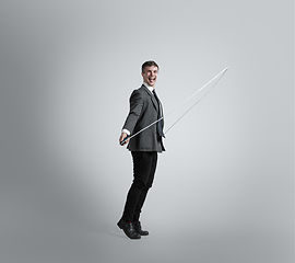 Image showing Caucasian man in office clothes training isolated on grey studio background