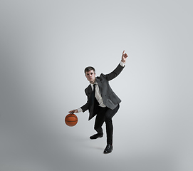 Image showing Caucasian man in office clothes training isolated on grey studio background