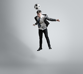 Image showing Caucasian man in office clothes training isolated on grey studio background