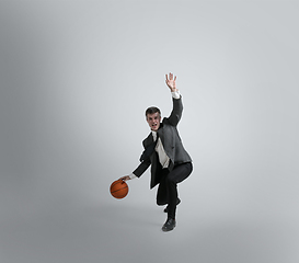 Image showing Caucasian man in office clothes training isolated on grey studio background